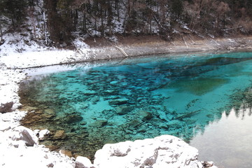 beautiful landscape of a lake in national park, Sichuan China with snow and reflection of the trees in the water