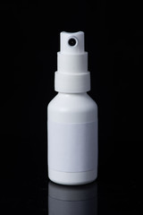Pharmacy. Throat spray medication in white bottle isolated on black background. medical container