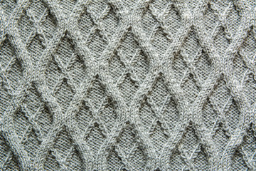 Grey knitted wool texture of a fabric with cable knit pattern