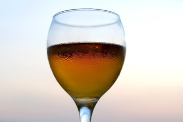 Cold beer in a fancy glass. Selective focus, beautiful evening bokeh.