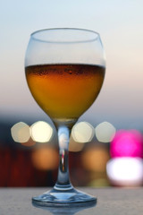 Cold beer in a fancy glass. Selective focus, beautiful evening bokeh.