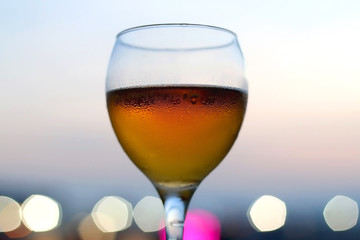 Cold beer in a fancy glass. Selective focus, beautiful evening bokeh.
