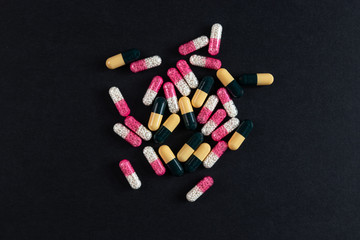 Some drugs and capsules on a black background