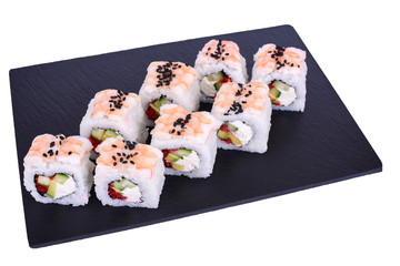 Traditional fresh japanese sushi rolls on a black stone Ebi Dragon on a white background. Roll ingredients: tiger shrimp, philadelphia cheese, avocado, red tobiko caviar, black sesame, nori, rice.