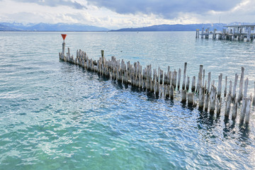 Wood piles in the lake, thunderstorm clouds over mountains