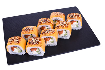 Traditional fresh japanese sushi rolls on a black stone Dragon cheeses on a white background. Roll ingredients: philadelphia cheese, cheddar cheese, salmon, cucumber, unagi sauce, white sesame, nori, 