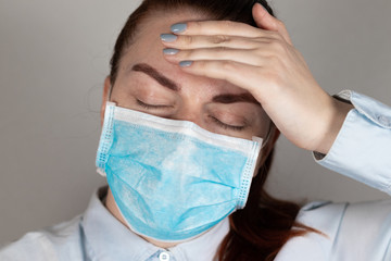 Girl in a medical mask. Headache, depression, stress. Protection against viruses and germs. Coronavirus Epidemic. Covid 19.