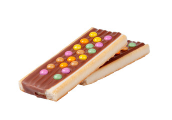 Chocolate bar snack with colorful drops or dragee isolated on the white