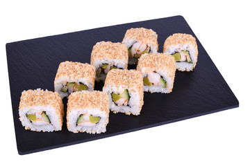 Traditional fresh japanese sushi rolls on a black stone Yokohama on a white background. Roll ingredients: tiger shrimp, daikon radish, cucumber, spicy sauce, nori, rice, white sesame.