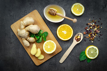 Pieces of ginger. Composition with lemon, honey and mint on black background. Top view, flat lay, copy space