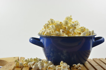 popcorn in a blue bowl on the table isolated background
