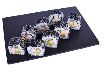 Traditional fresh japanese sushi rolls on a black stone Hokaido on a white background. Roll ingredients: surimi, daikon radish, cucumber, spicy sauce, nori, rice, black tobik.