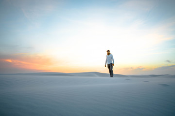 Fototapeta na wymiar man in a white desert at sunset