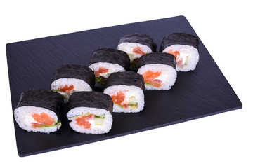 Traditional fresh japanese sushi futomaki on black stone Futomaki Syake on a white background. Roll ingredients: salmon, philadelphia cheese, cucumber, bell pepper, lettuce, nori, rice.