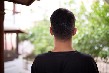 rear view of man looking out refugee camp