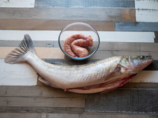 large gutted fish on table and caviar in glass bowl. Zander