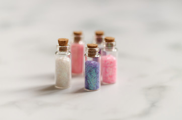 small jars with sequins for artwork on a light background