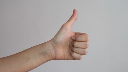 Thumb up of a left female hands on white background.