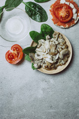 Fresh mushrooms with tomatoes on grey background. Vegan healthy food concept
