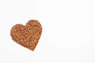 Heart from buckwheat isolated on white background. Concept of healthy food. Space for text.