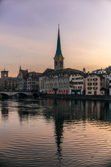 Fototapeta premium View of the riverside of the Limmat and the deserted old town of Zurich during the Coronavirus lockdown at sunset