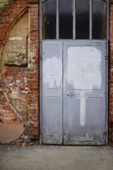 The old door. Gray door in a brick house.