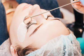 Eyelash Extension Procedure - Master Evaluates Work Using a Round Mirror