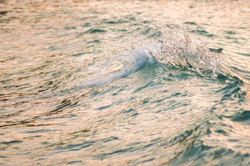 Colorgraded waves splashing on the shore during sunset