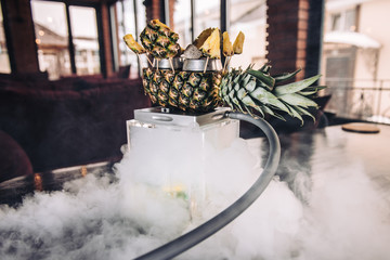 Hookah with pineapple in the smoke. Original square designer hookah