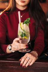 Mojito cocktail with lime mint and ice side view. Refreshing drink with a straw