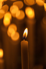 Close up of lit candle with other candles out of focus in the background