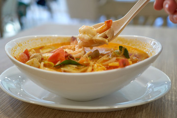 Hot Tom Yam Kung soup with shrimps in thai restaurant in Bangkok, Thailand.