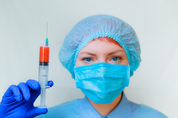 a doctor holds a red injection in his hands