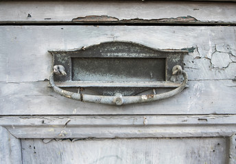 Close up of old mail slot in wooden door