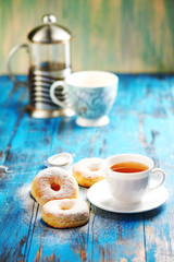 Homemade donuts with tea in the afternoon a wooden blue background.