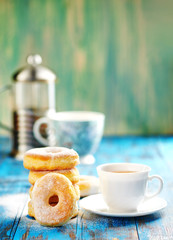 Homemade donuts with tea in the afternoon a wooden blue background.