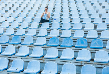 Fototapeta premium Woman athlete knitting a sweater on a football field