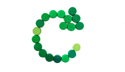 Recycle symbol in green color made with bottle caps on isolated background