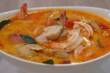 Closeup of a hot Tom Yum Kun soup with shrimps in thai restaurant in Bangkok, Thailand.