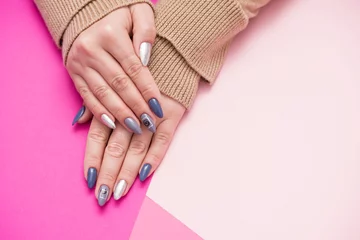  Beautiful well-groomed women's hands with an interesting manicure on a pink background. Painted with modern gel-polish with top cover. © Eugenia Sh