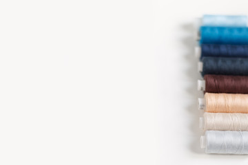 close-up of colored sewing threads on a light background with a place for the inscription.