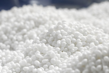 Closeup of a lot of granules of a white plastic polymer