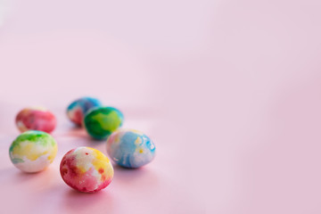 Colorful Easter eggs in watercolor style. Pink background with a copy of the text space. The view from the top down or flat lay
