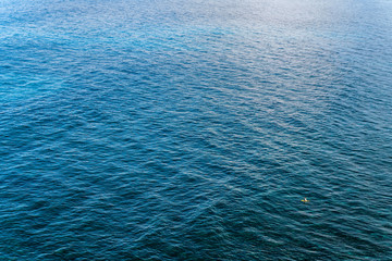 The smooth surface of the ocean. The ocean near the Bukit Peninsula in Indonesia. Azure sea natural background.