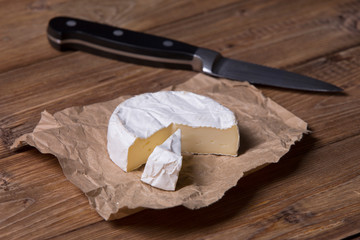 Fototapeta na wymiar blue brie cheese, wooden table and knife 