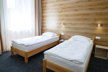 Large bright room in a hostel with three beds. White bedding - obrazy, fototapety, plakaty
