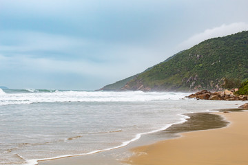 Fototapeta na wymiar Mar revolto na costa verde da praia de Açores, Florianópolis - SC, Brasil