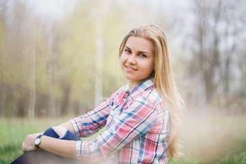 Beautiful girl in flowering trees in early spring. Bright sun and nature