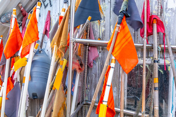 Flags of different colors used for fishing gear. some old fishing flags standing up by a fishing house.