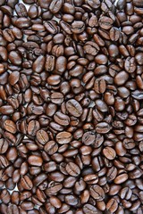Roasted Coffee beans background with selective focus. Arabica coffee seeds. 
Vertical position 